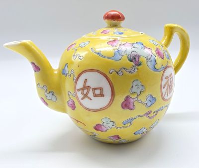 une théière jaune ornée d'un motif floral