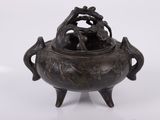 un petit pot en bronze orné de deux oiseaux