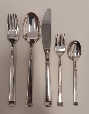 quatre fourchettes, deux cuillères et un couteau sur une table