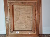 an old picture frame with a piece of paper in it sitting on a table