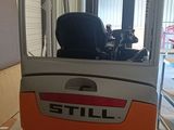 a forklift truck parked in a garage with a door open