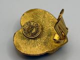 a close up of a gold pin with a flower on it