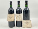 trois bouteilles de vin posées l'une à côté de l'autre sur une table