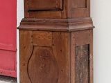 an old wooden grandfather clock on the corner of a building