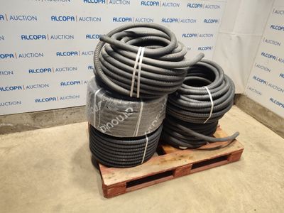 several hoses are stacked on a pallet in front of a wall