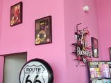 a pink wall with pictures on it and a route 66 sign on the wall