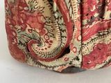 a close up of a purse with a red paisley pattern