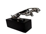 sculpture représentant un chien posé sur un bloc, sur fond blanc