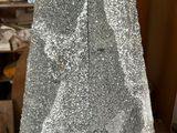 the back of a silver dress with silver sequins on it