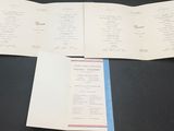 a menu on a table with a cup of coffee on it