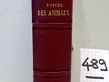 un vieux livre rouge posé sur une table, à côté d'un bloc-notes