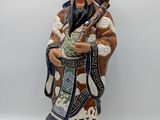 an image of a figurine of a man holding a bag of money