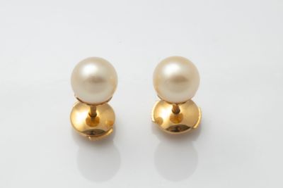 pair of pearl and gold earrings on a white background
