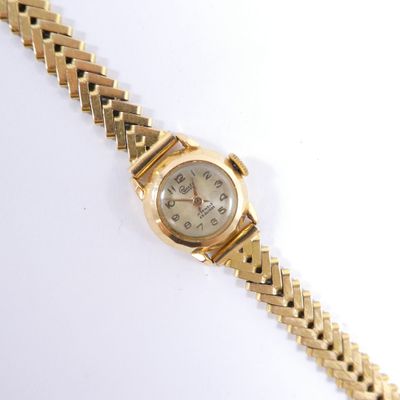 une image d'une montre-bracelet en or sur une surface blanche