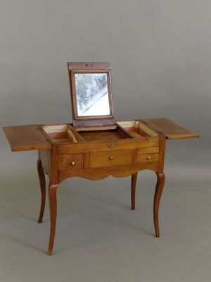 a small wooden table with a mirror on top of it