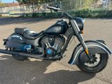 une moto noire garée dans la rue, sur un parking