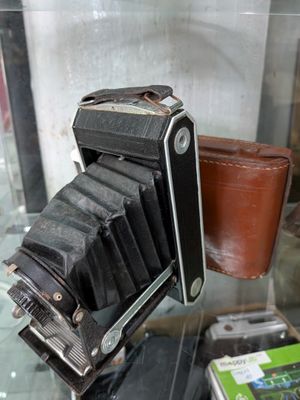 un vieil appareil photo et un portefeuille exposés dans une vitrine