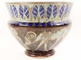 a blue and white bowl sitting on top of a wooden stand