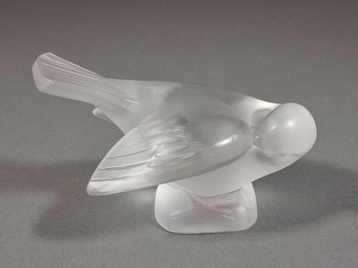 un oiseau en verre posé sur une table