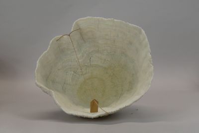 a white bowl that has a small wooden handle in it