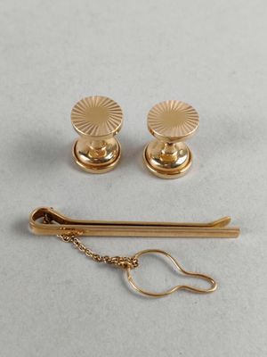 a close up of a pair of gold earrings and a pair of scissors