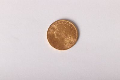 a close up of a gold coin on a white surface