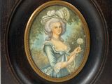 portrait d'une femme en robe bleue tenant une fleur