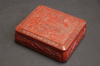 une boîte orange posée sur une table, sur fond noir