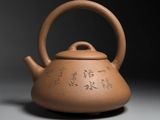 teapot with writing on it on a gray surface