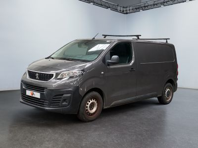La camionnette grise est garée dans une grande pièce équipée d'une galerie de toit.