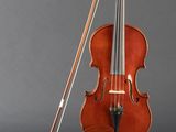 an old violin sitting on top of a clear stand next to a bow