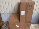 trois cartons sont empilés sur une palette devant un bâtiment