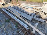 a pile of wood sitting on the ground next to a pile of pipes