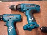 two electric tools are sitting on a table next to each other