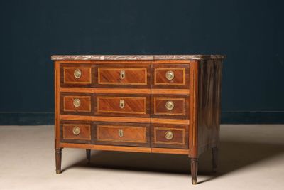 an antique chest of drawers with marble top in a dark room
