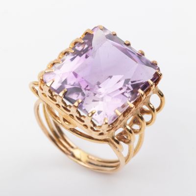 an amethorate and gold ring with a square cut amethorate surrounded by filigree