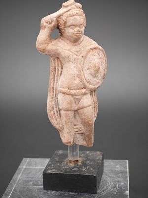 une statue représentant un homme tenant un bouclier, posée sur un bloc de marbre