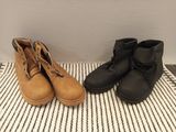 two pairs of brown and black boots sitting on top of a rug