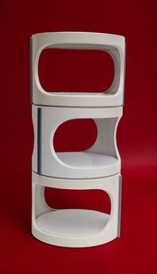 a stack of three white shelves on a red background