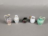 several small vases are lined up in a row on a gray surface