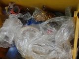 une boîte jaune posée sur une table, remplie d'objets emballés dans du plastique