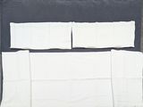 une photo d'un morceau de tissu blanc posé sur une surface noire
