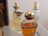 bottles of perfume sitting on a glass shelf next to a book