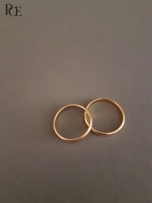 deux alliances en or posées sur un morceau de papier