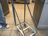 someone is pushing a dolly cart in a kitchen with a counter in the background
