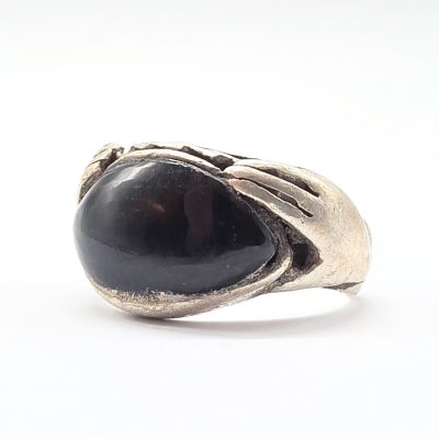 une image représentant une bague avec une pierre noire au centre