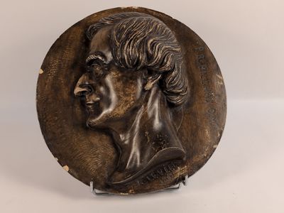 une image représentant une plaque en bronze représentant la tête d'un homme