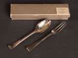 two spoons and a fork sitting next to a box