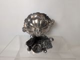 a silver vase sitting on top of a clear table