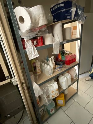 a shelf with toilet paper, toilet paper rolls, and other items on it